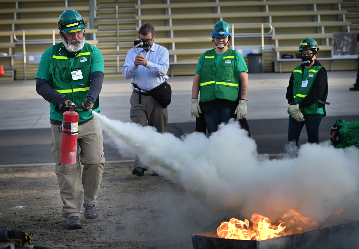 CERT trainee Michael Haughey uses a fire extinguisher to put out a fire during a drill at OCFA headquarters in Irvine. Photo by Steven Georges/Behind the Badge